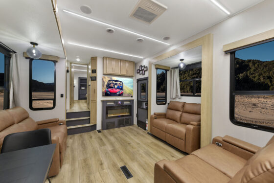 Interior of the 2024 Heartland Cyclone 4008 Fifth Wheel Toy Hauler living room, featuring plush seating, an entertainment center, and modern décor.