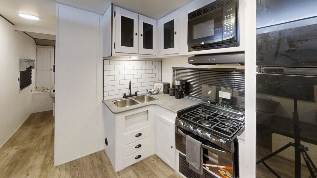 Interior view of the kitchen in the 2024 Trail Runner 31DB travel trailer, featuring modern appliances and ample counter space.