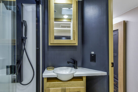 Spacious and modern bathroom inside the 2025 Heartland Cyclone 4215, featuring a large vanity, sink, mirror, and ample storage.