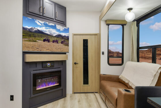 Interior of the 2025 Heartland Cyclone 4215 featuring a modern kitchen with stainless steel appliances, a spacious living area, and stylish cabinetry.