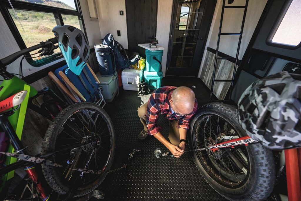 Spacious garage area inside a Heartland Cyclone toy hauler, featuring durable flooring, overhead storage, and tie-downs for securing cargo or recreational vehicles.