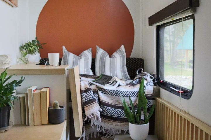 A beautiful, modified RV room with a fold-up desk and cozy bench seating.