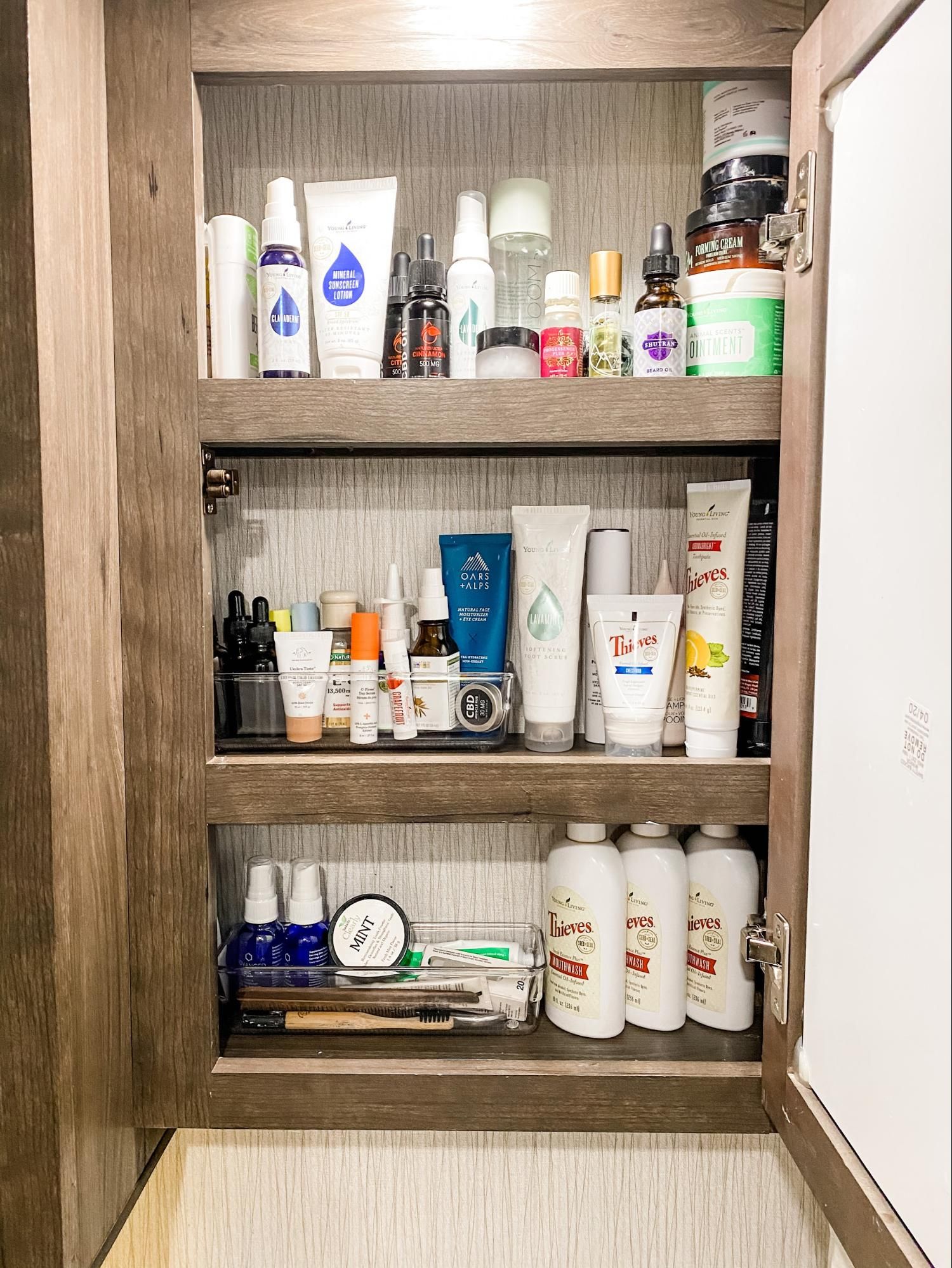 A bathroom medicine cabinet with storage containers grouping small items.