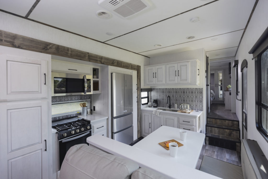 Inside the Bighorn Traveler RV, with a long shot of the luxury kitchen.