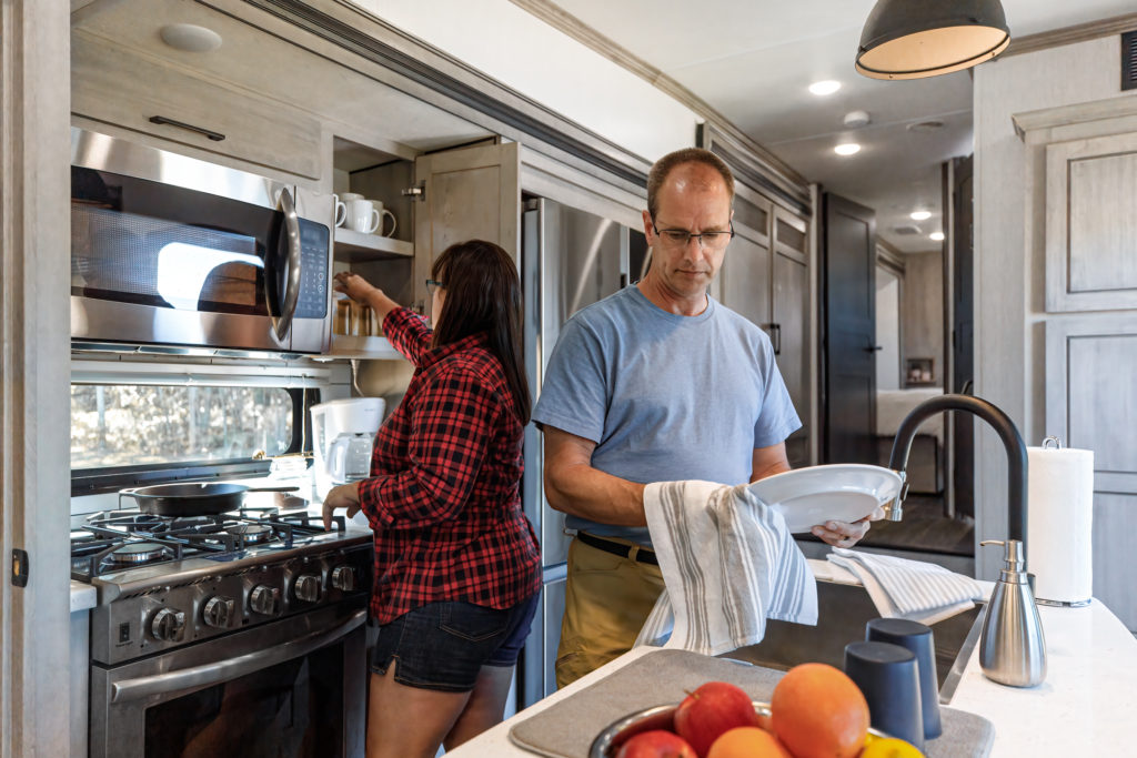 An older ocuple in the kitchen of a fifth wheel RV.