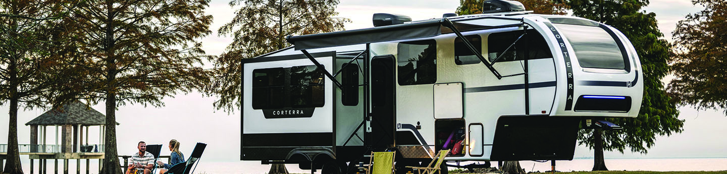Front and side view of a Heartland Corterra fifth-wheel RV, featuring a modern design, large windows, and multiple slide-outs.